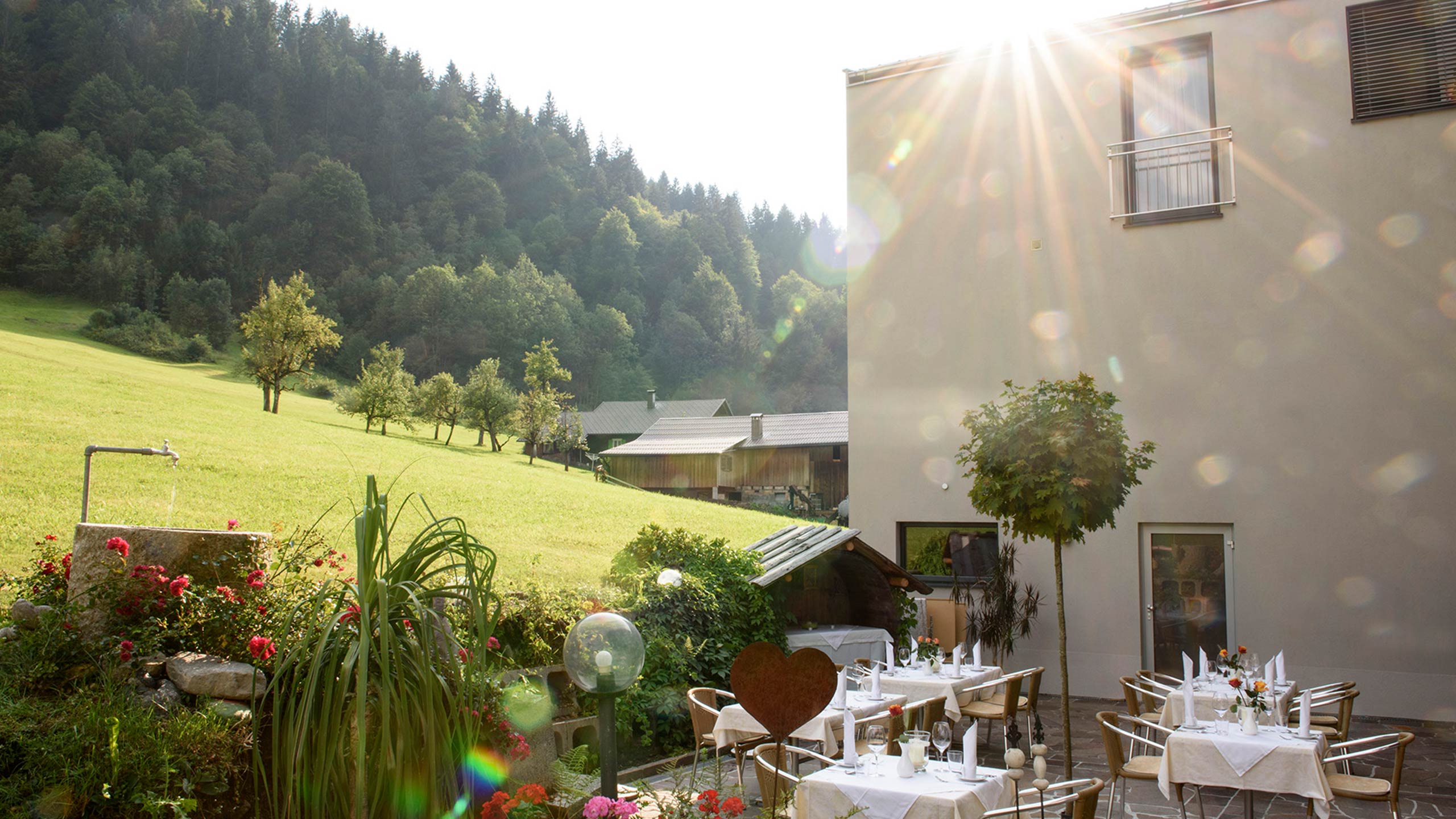 Gastgarten und Rückseite des Hotel Silbertal mit Blick auf die Bergwelt des Montafon
